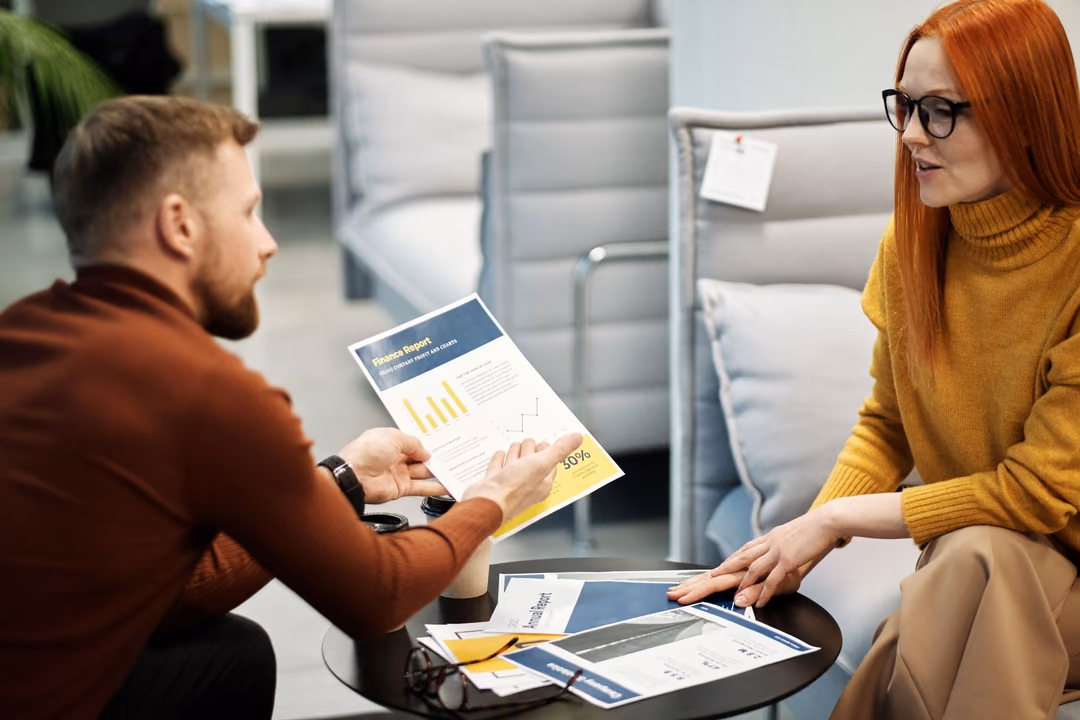 Zwei Personen besprechen Unterlagen an einem Tisch