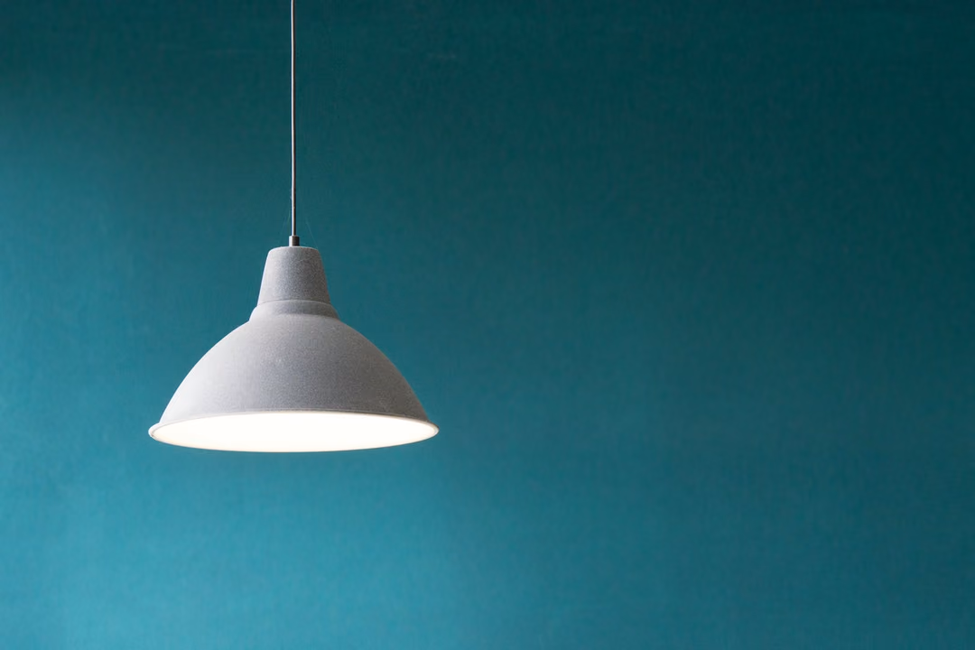 Minimalistische Pendelleuchte an farbiger Wand