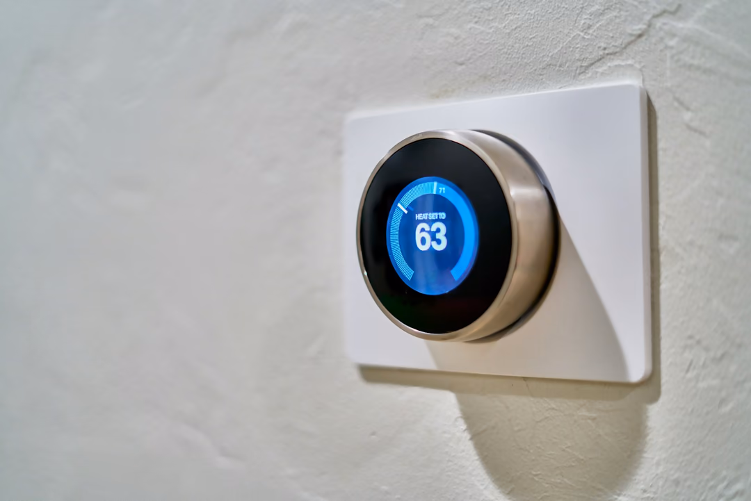 Modernes Thermostat an heller Wand
